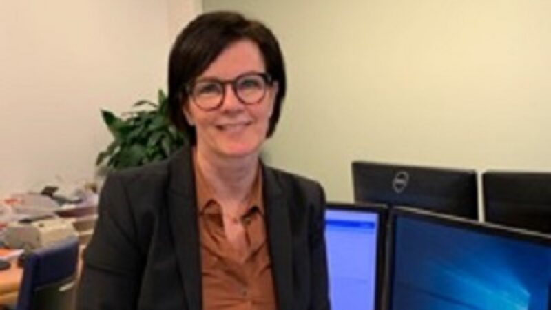 Vrouw poseert voor haar bureau